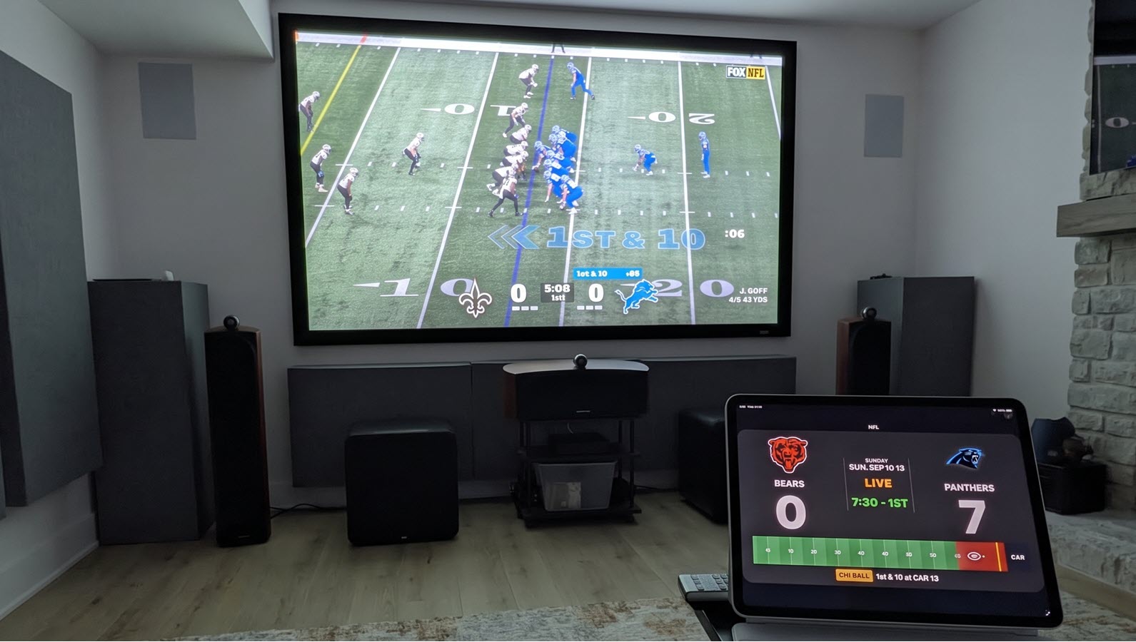TickrDash live sports scoreboard on a wall-mounted TV and a tablet in a basement den